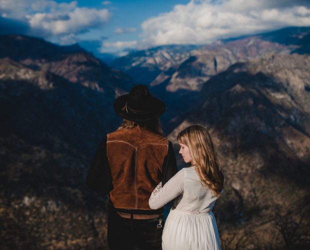 Adventurous wedding photography in Sequoia National Park of a bride and groom posing for their portraits overlooking the Sierra Nevada mountains in California.
