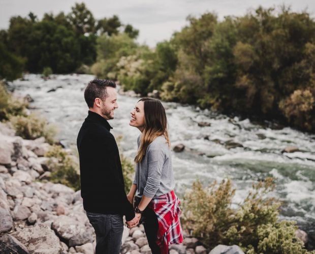 A couple holds hands during their engagement session at Clark County Wetlands Park in Las Vegas.