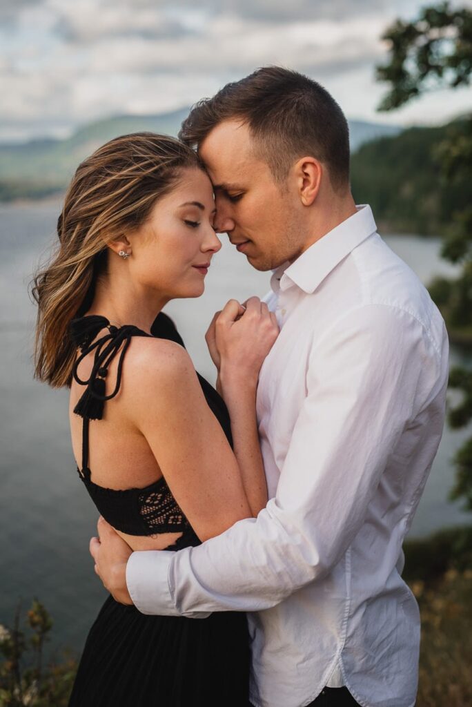 A couple leans their foreheads together while posing during their engagement session in the Columbia River Gorge in a photo by Portland Wedding Photographer Kyle Carnes.