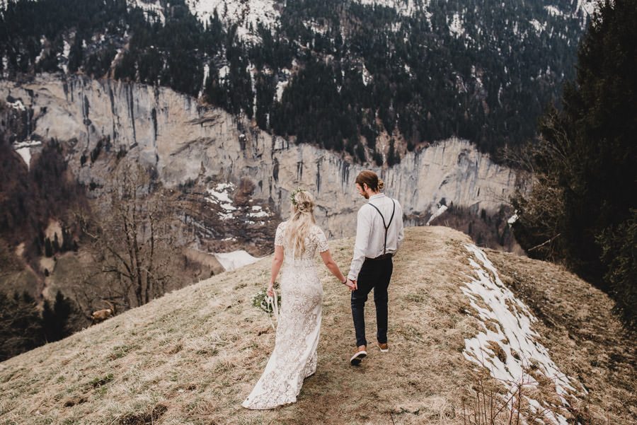 Bride and Groom holding hands overlooking the alps in Switzerland