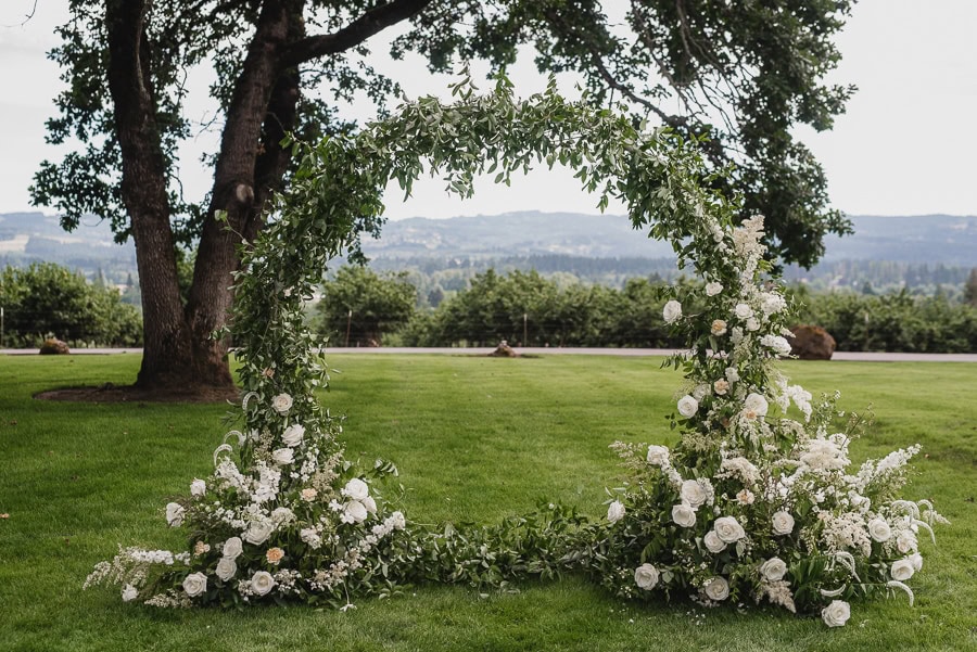 A beautiful circular ceremony flower arch arrangement at a Scholls Valley lodge wedding.