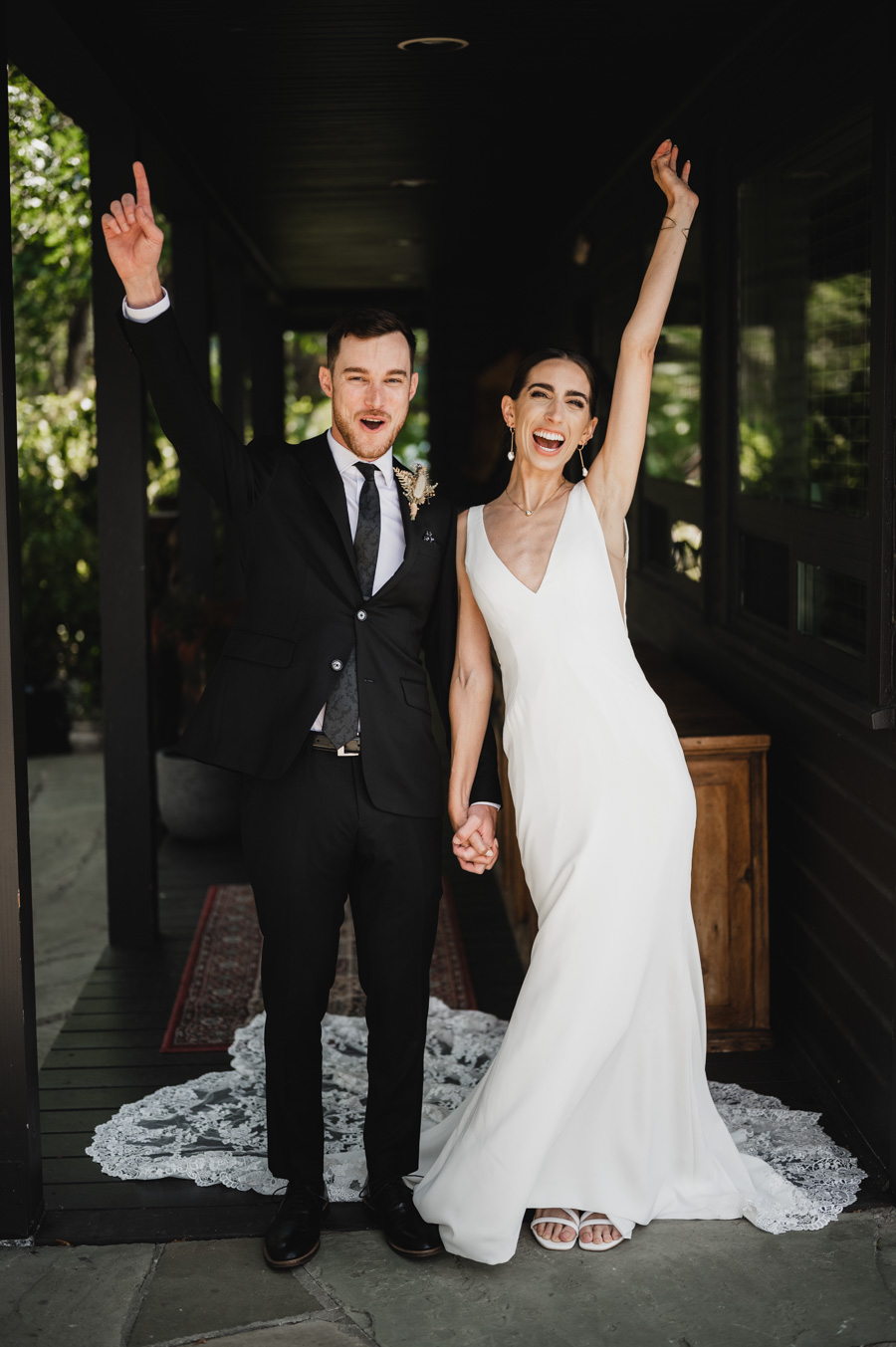 A portrait of newlyweds cheering during their wedding photographed by Portland wedding photographer Kyle Carnes.